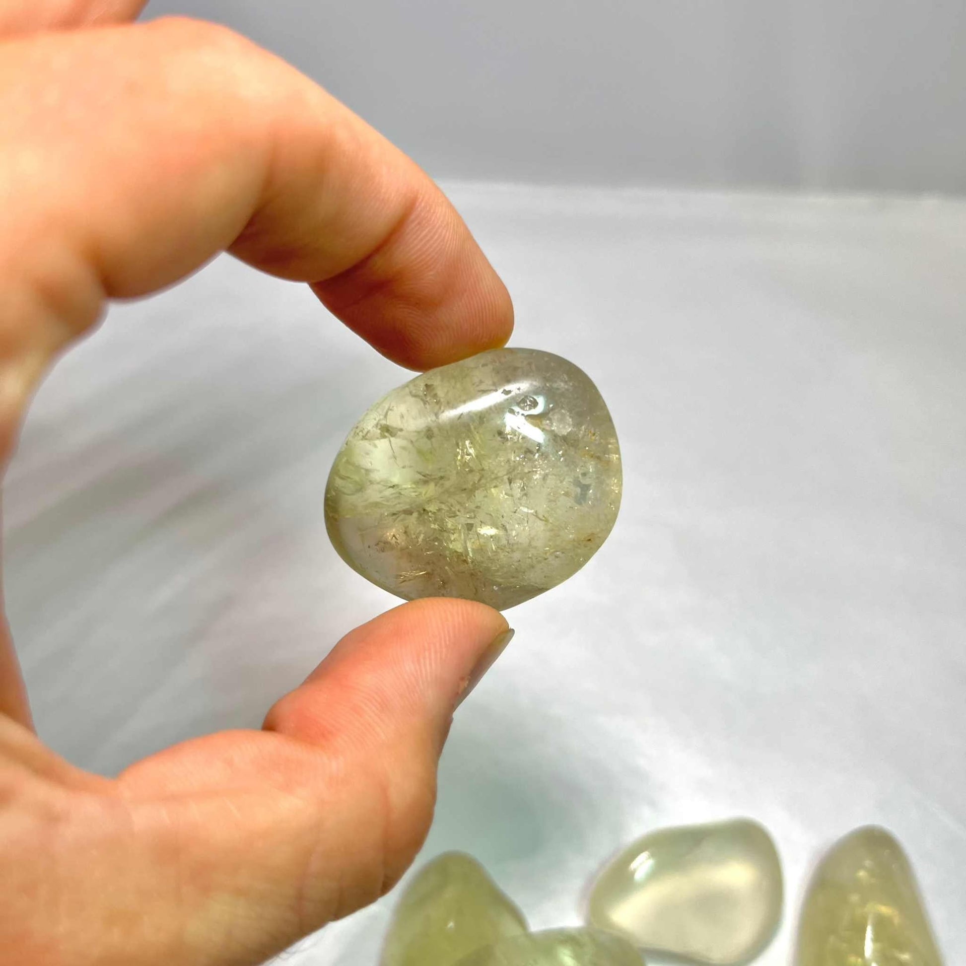 Pale golden natural citrine tumbled stone with warm translucency, detail view