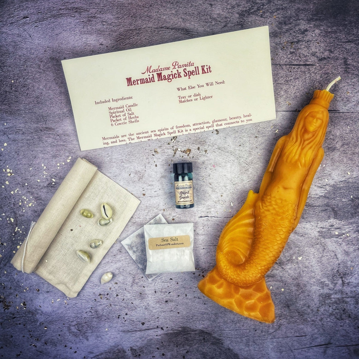 Amber-yellow mermaid candle with the kit, the wax translucent along the tail.