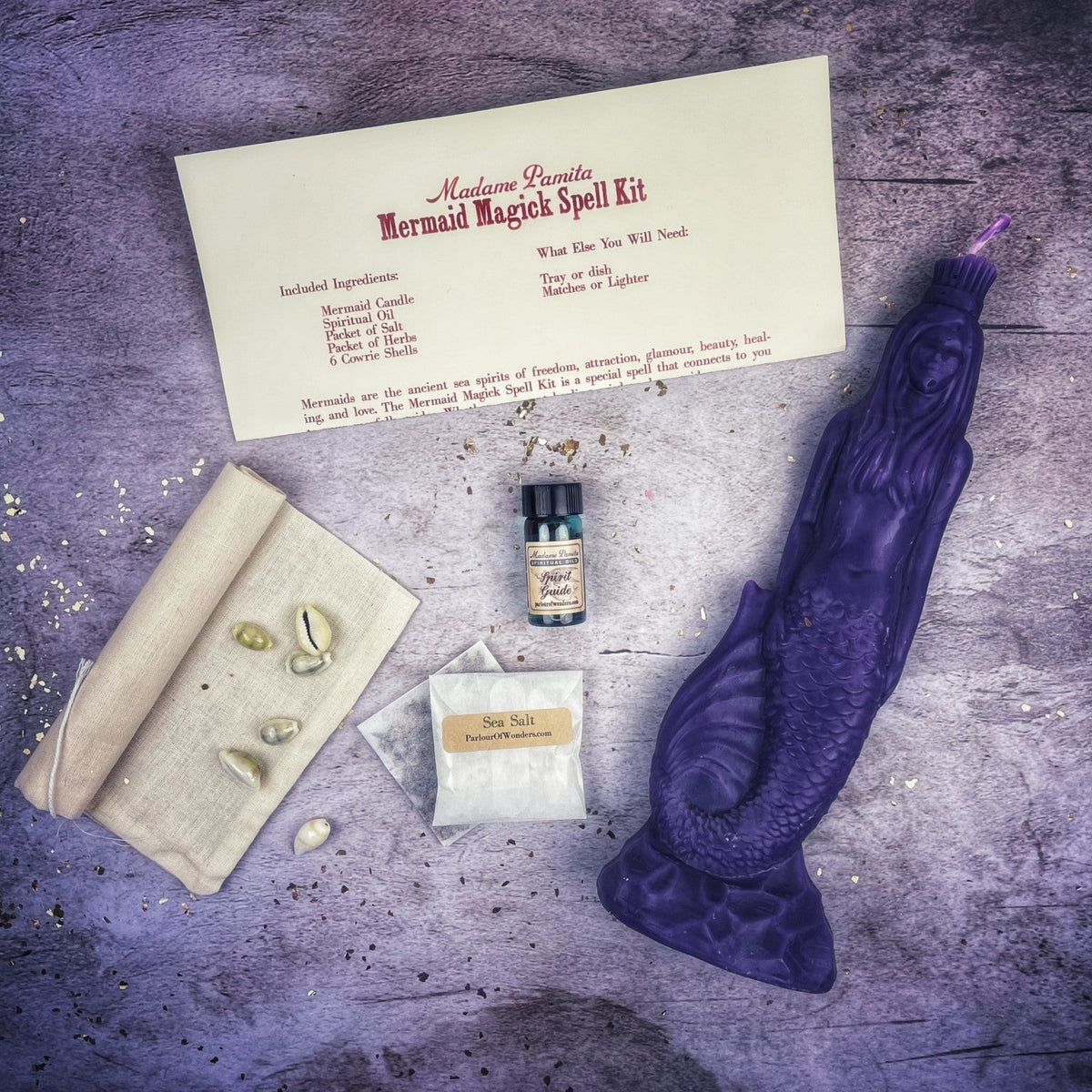 Purple mermaid candle with the kit, the tail molded in overlapping scales.