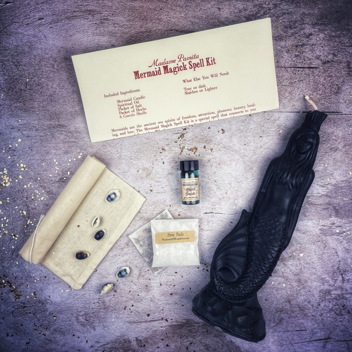 Black mermaid candle with the kit, the figure readable through the highlights on the wax.