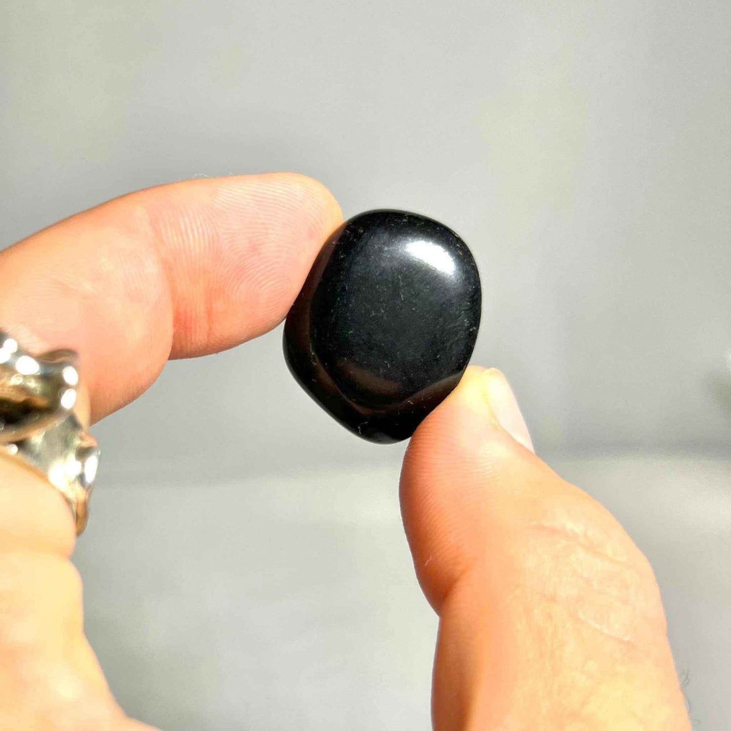 Several Black Obsidian tumbled stones showing natural variation