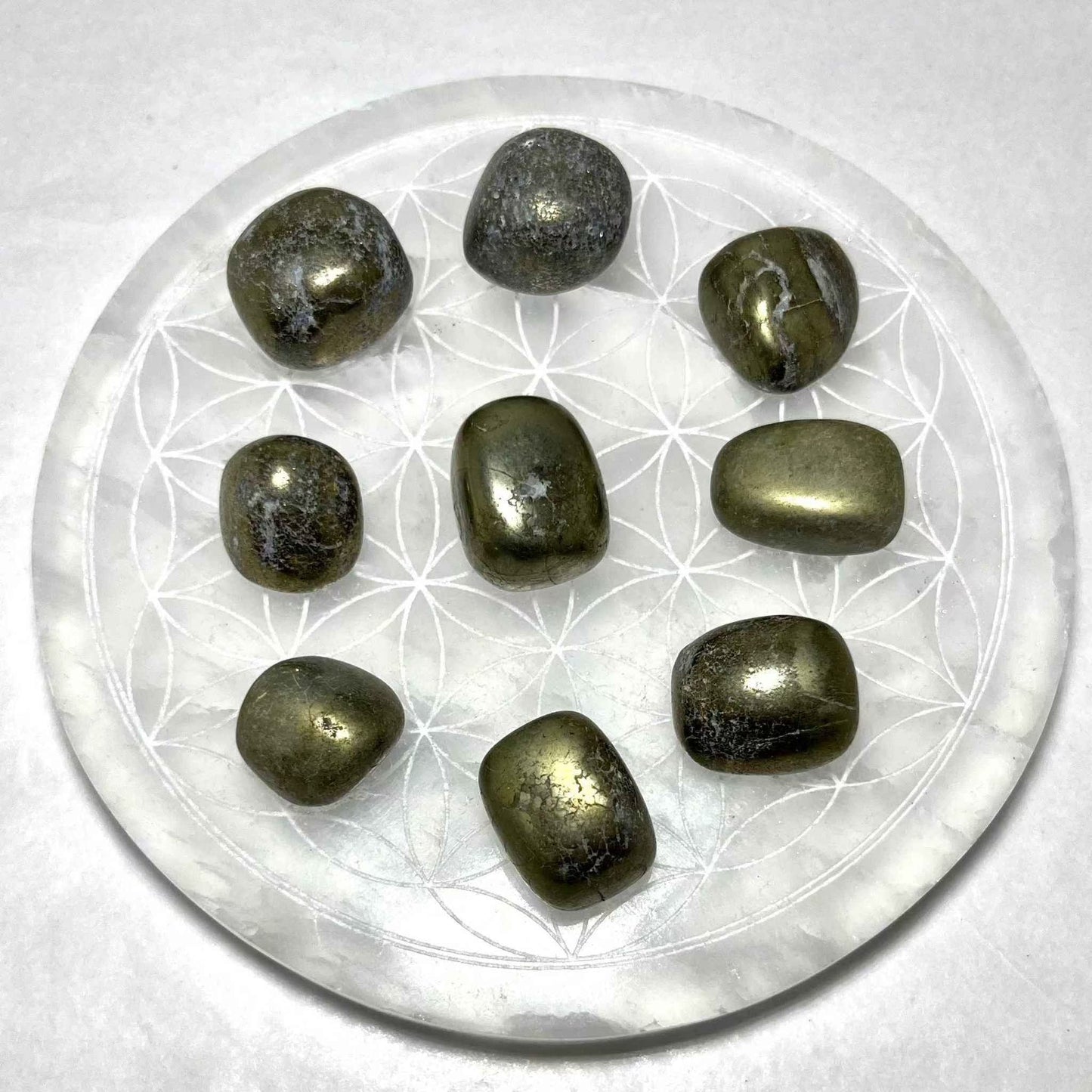 Tumbled Pyrite stone held to show its palm-friendly size