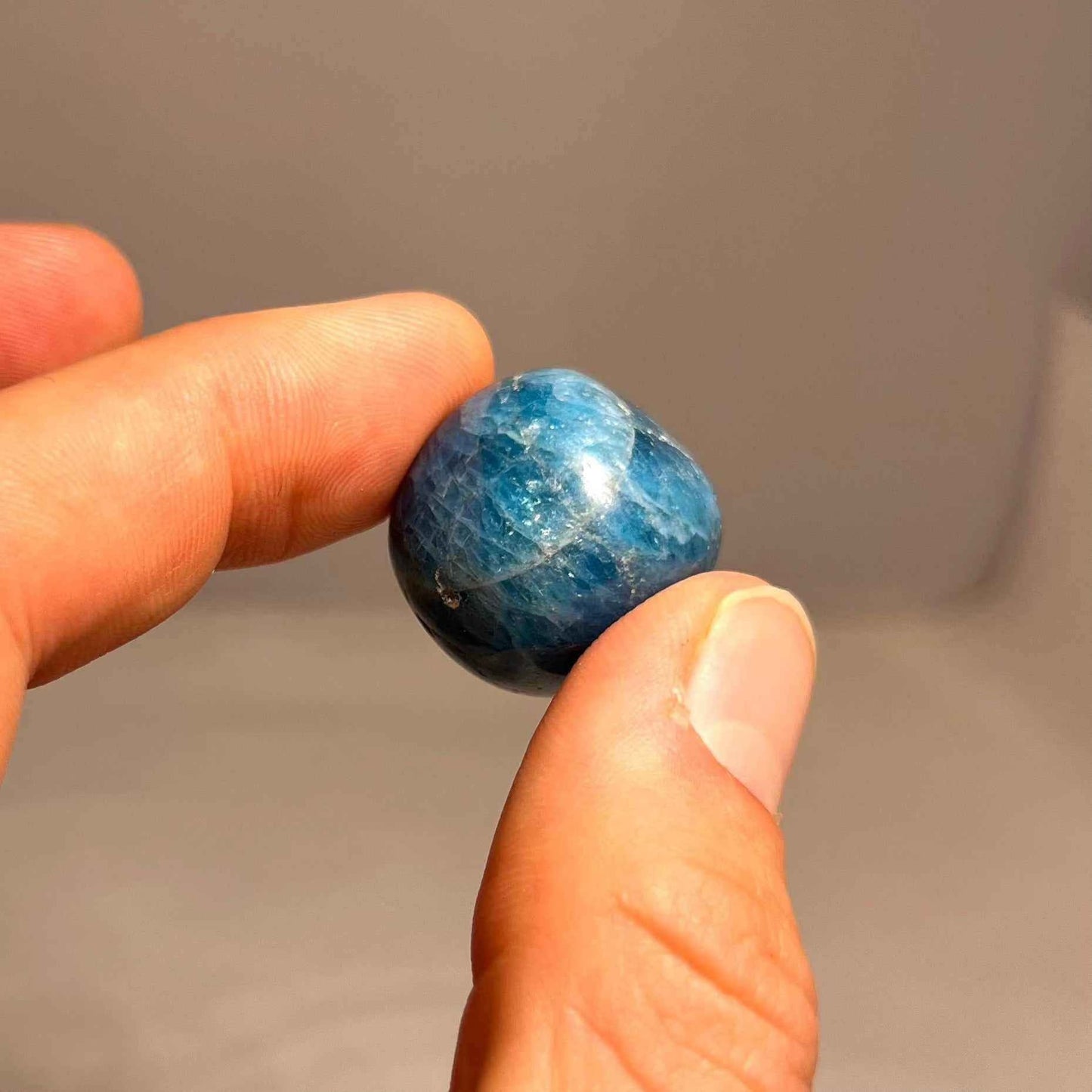 Tumbled blue apatite stones with natural color variation