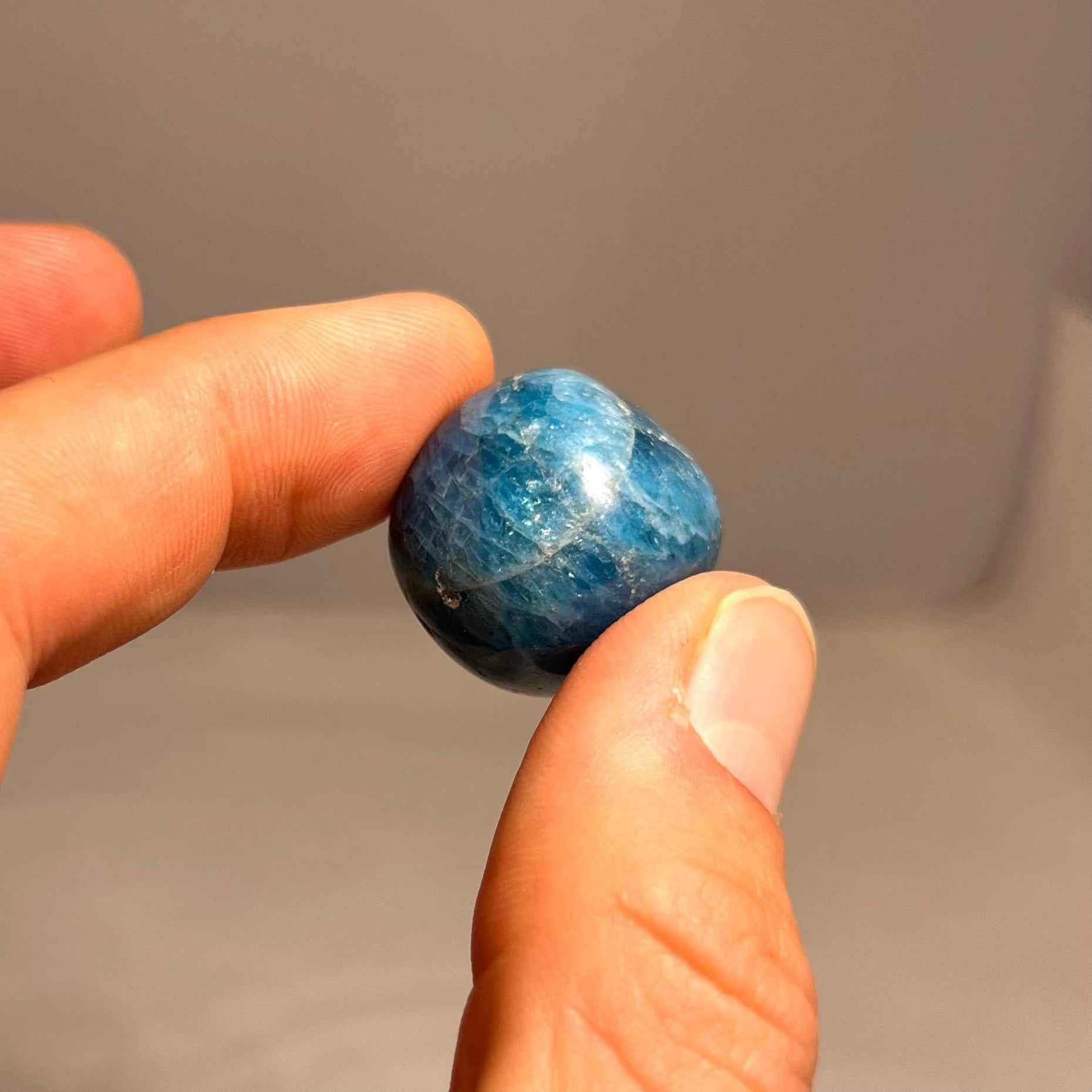 Tumbled blue apatite stones with natural color variation