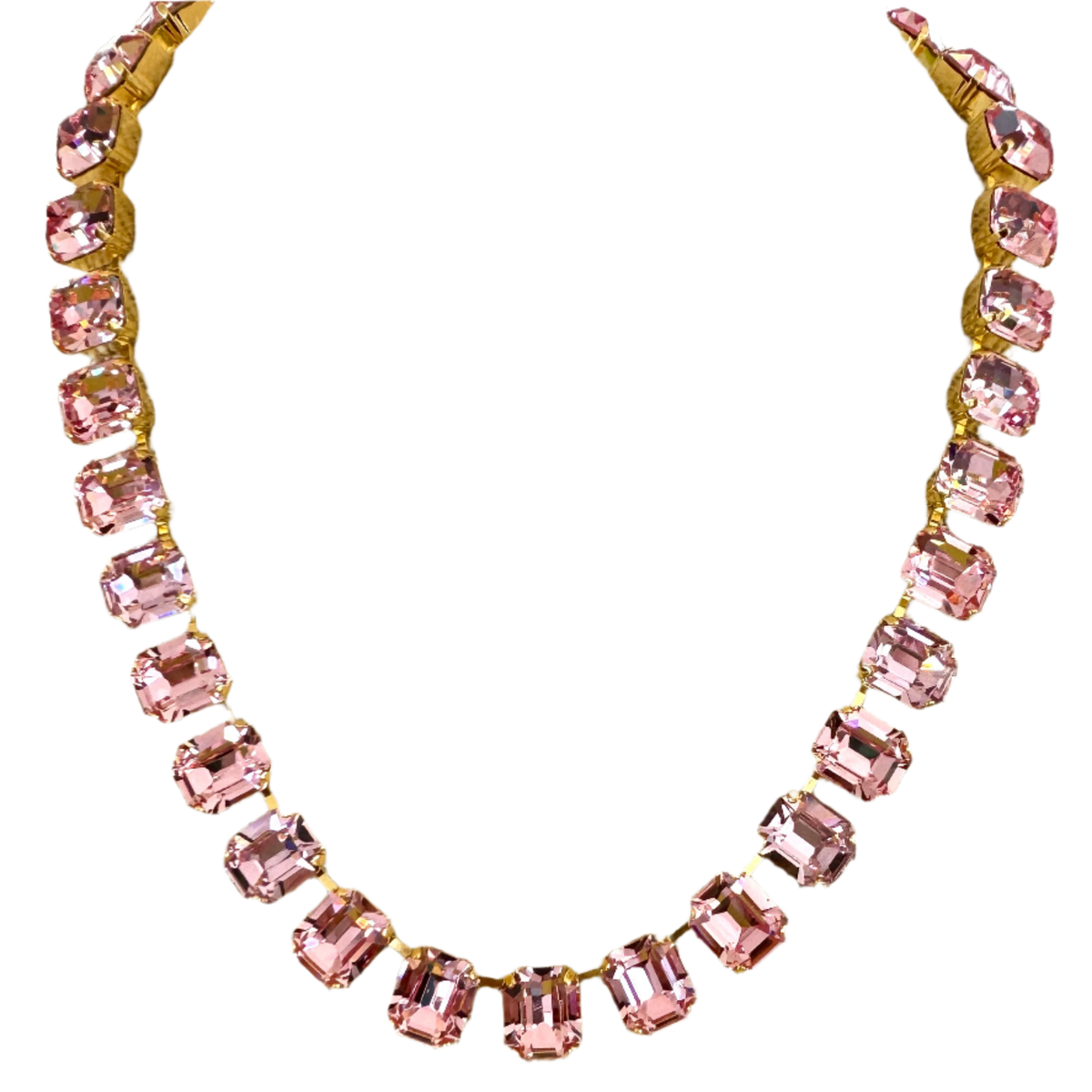 The pink emerald-cut crystal necklace on black, the stones held in gold-tone claw settings.