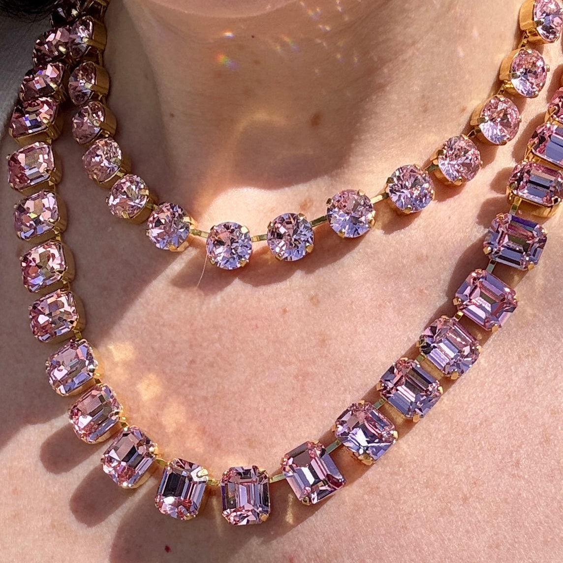 Two pink crystal necklaces worn layered, a round-stone strand above and an emerald-cut strand below; this listing is the emerald-cut necklace.