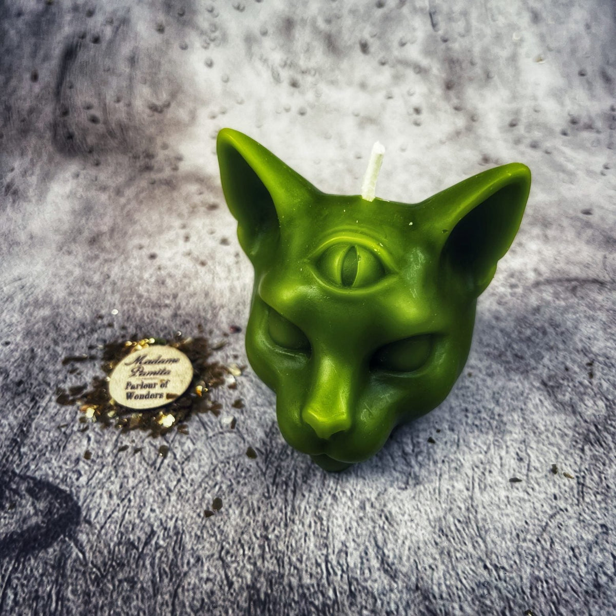 Green cat head candle, the vertical third eye open above the brows.