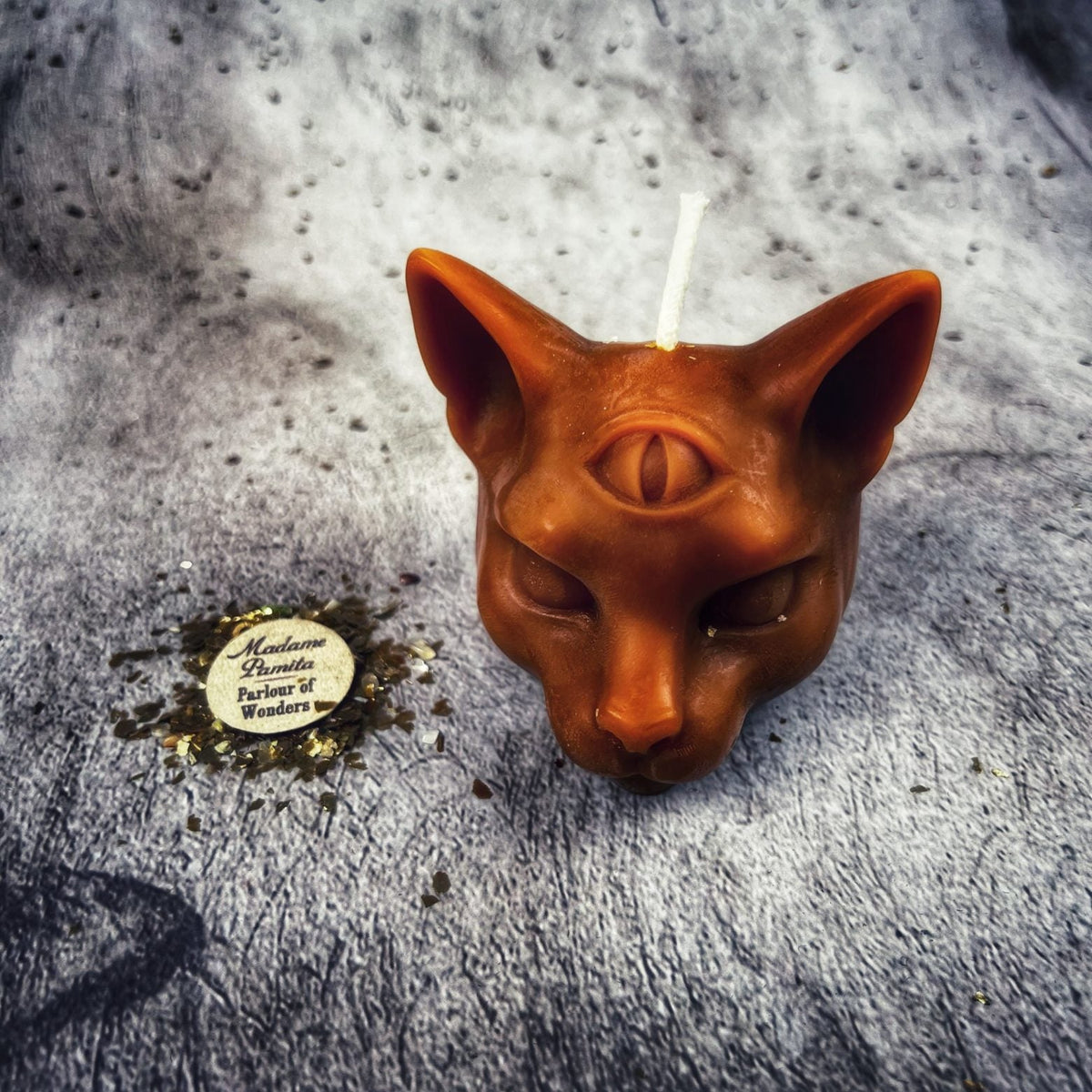 Rust-orange cat head candle, warmer and darker than the bright orange.
