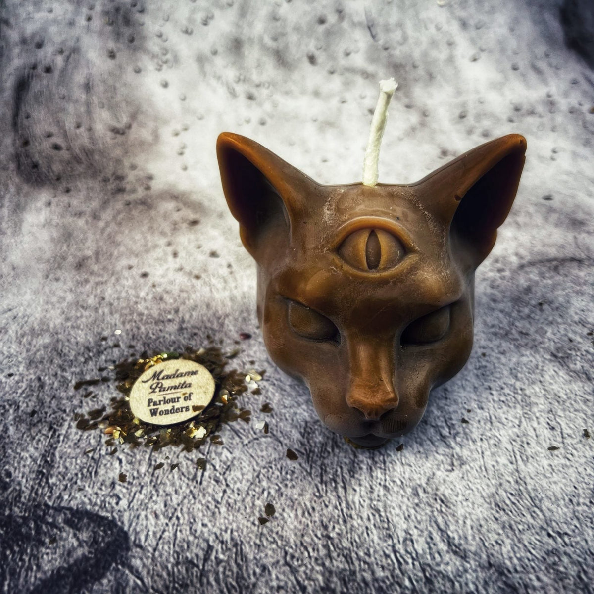 Brown cat head candle, the wax slightly mottled where it cooled.