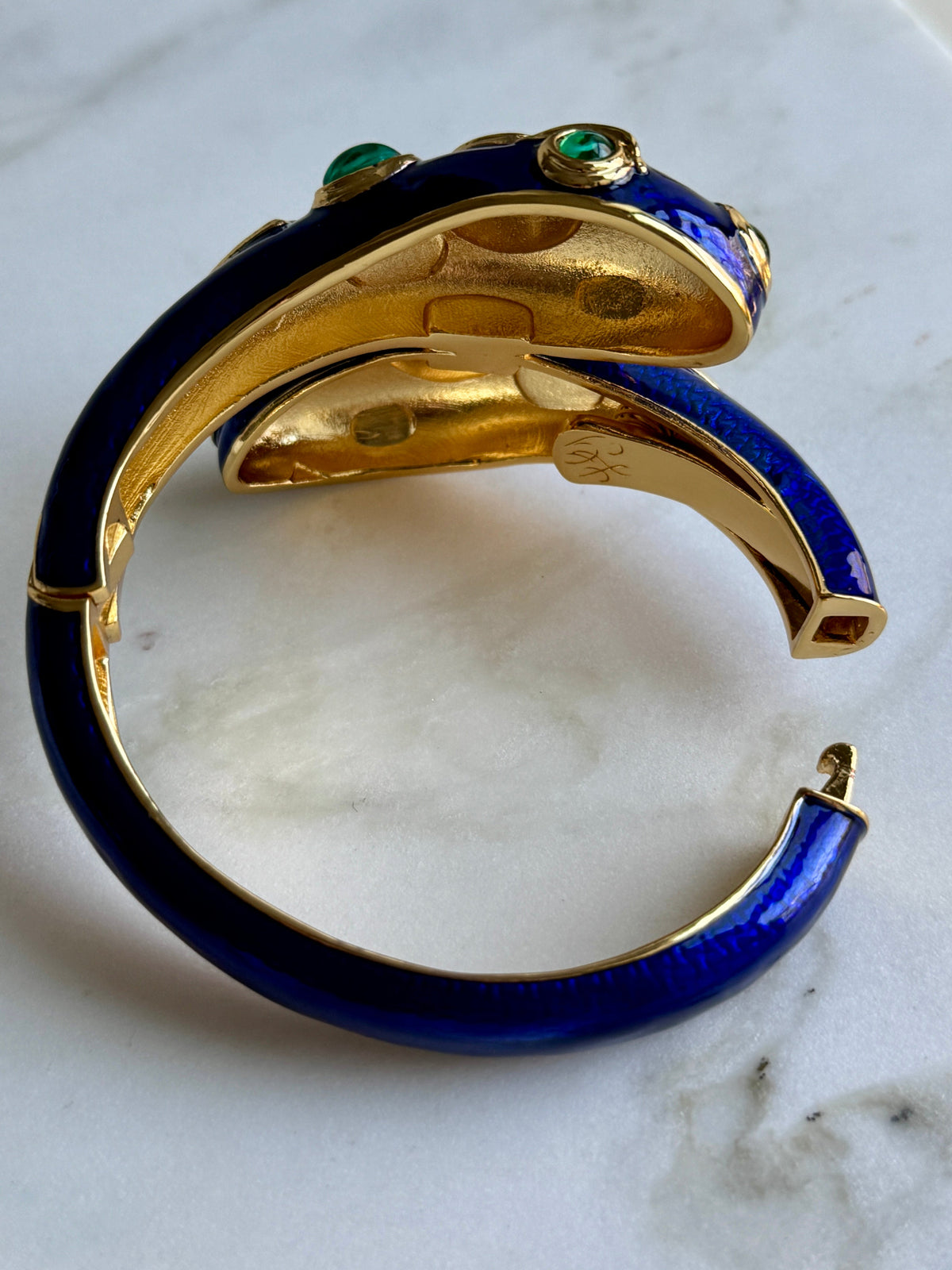 The cobalt blue cuff opened at the hinge, showing the clasp and the enamel running around the shank.