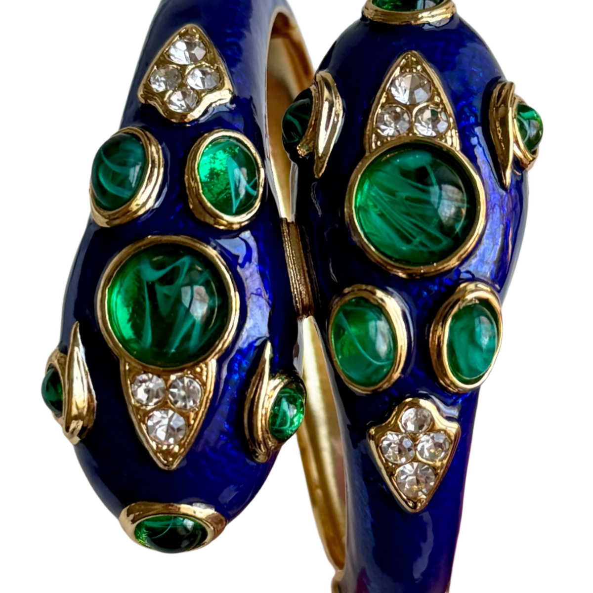 Close-up of the two heads in cobalt blue enamel with large swirled green cabochons and shield-shaped clear pavé panels.