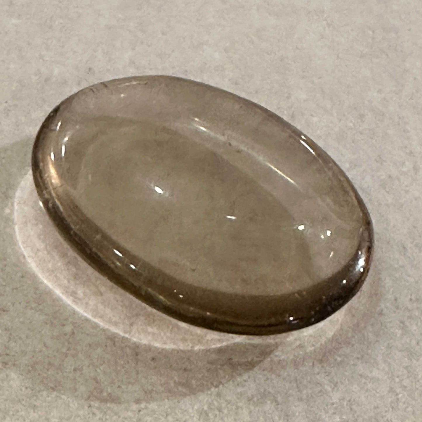 Smooth oval smoky quartz comfort stone in translucent grey-brown