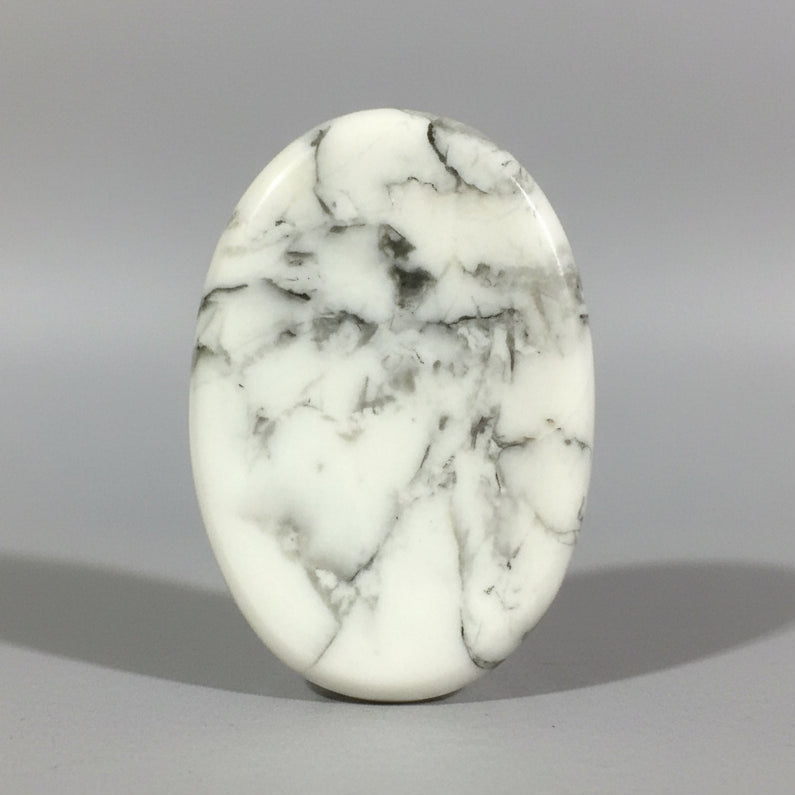 A smooth white howlite comfort stone with fine grey veining.