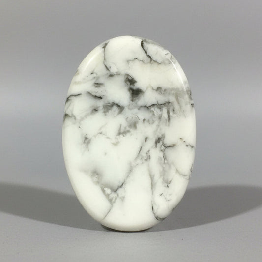 A smooth white howlite comfort stone with fine grey veining.