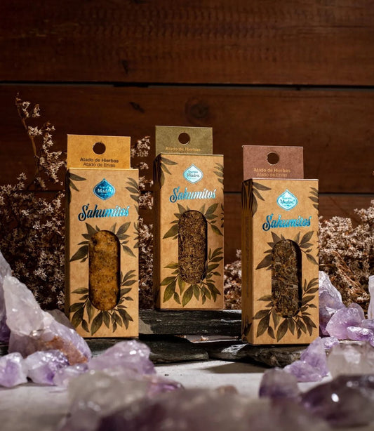 Three boxed smudge sticks standing among amethyst clusters and dried flowers