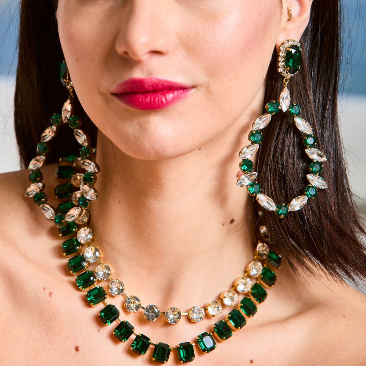 Model wearing the green emerald-cut necklace layered under a second clear-crystal strand, with large green and clear drop earrings; this listing is the green emerald-cut necklace only.