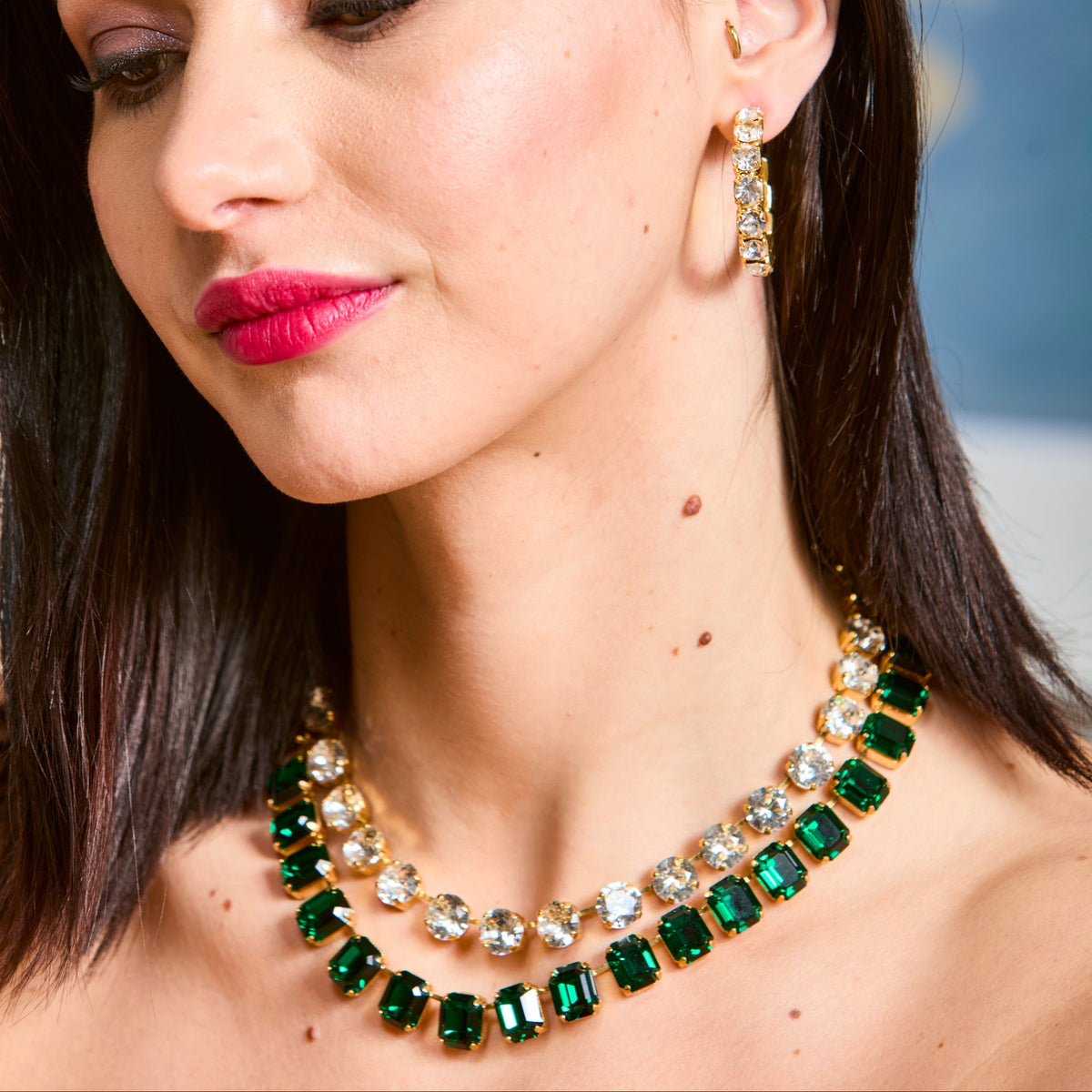 Model wearing the green emerald-cut necklace layered with a clear round-stone strand; only the green necklace is sold here.