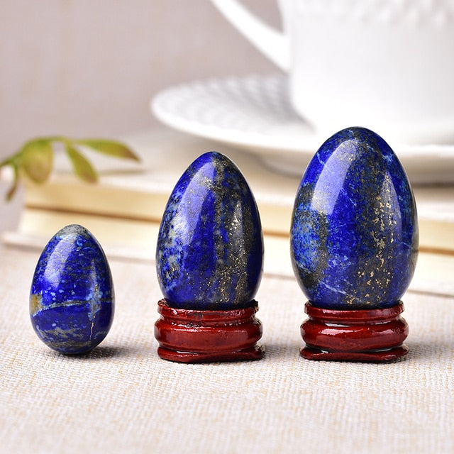 Polished carved crystal egg in assorted gemstones on a dark surface — view 5 of 10