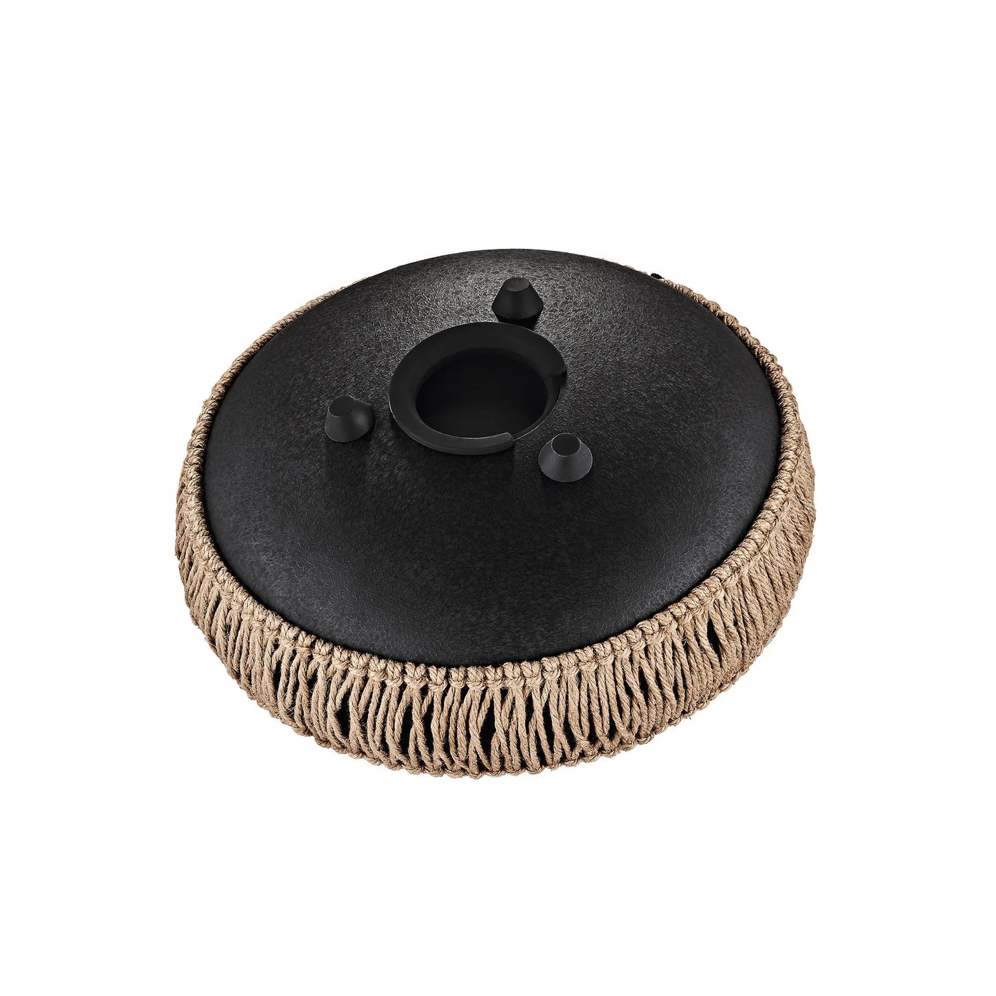 Black 10-inch steel tongue drum styled in a quiet, softly lit vertical scene.