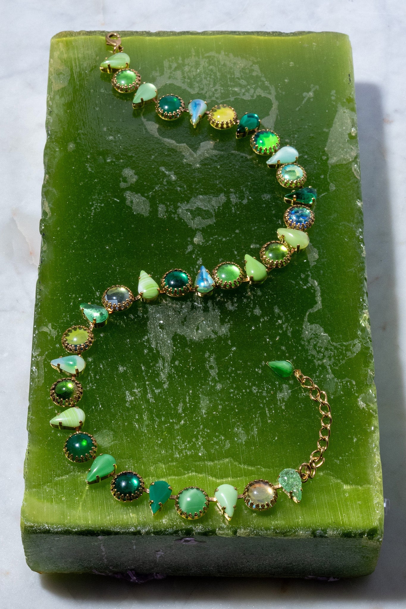 Detail of alternating round and fang-shaped green glass stones