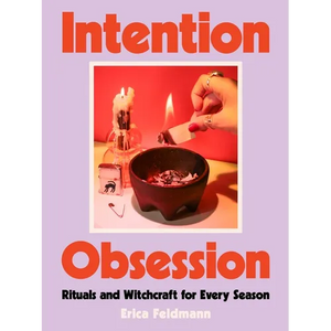 Front cover of Intention Obsession by Erica Feldmann: a lilac background with bold orange lettering and a photograph of hands lighting a candle over a dark ritual bowl.