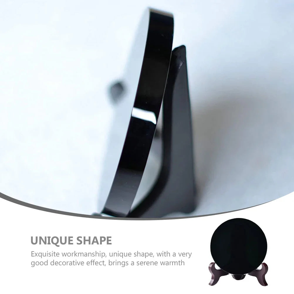 Round polished black obsidian scrying mirror resting on its base stand — view 4 of 11