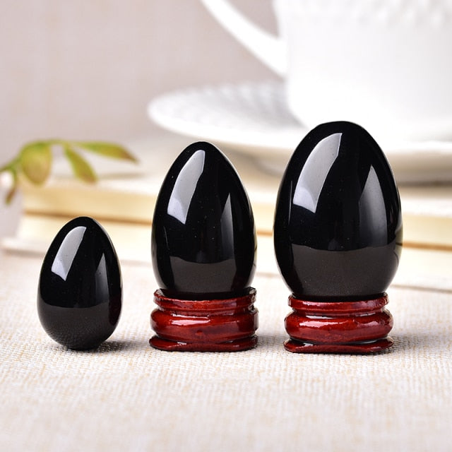 Polished carved crystal egg in assorted gemstones on a dark surface — view 6 of 10