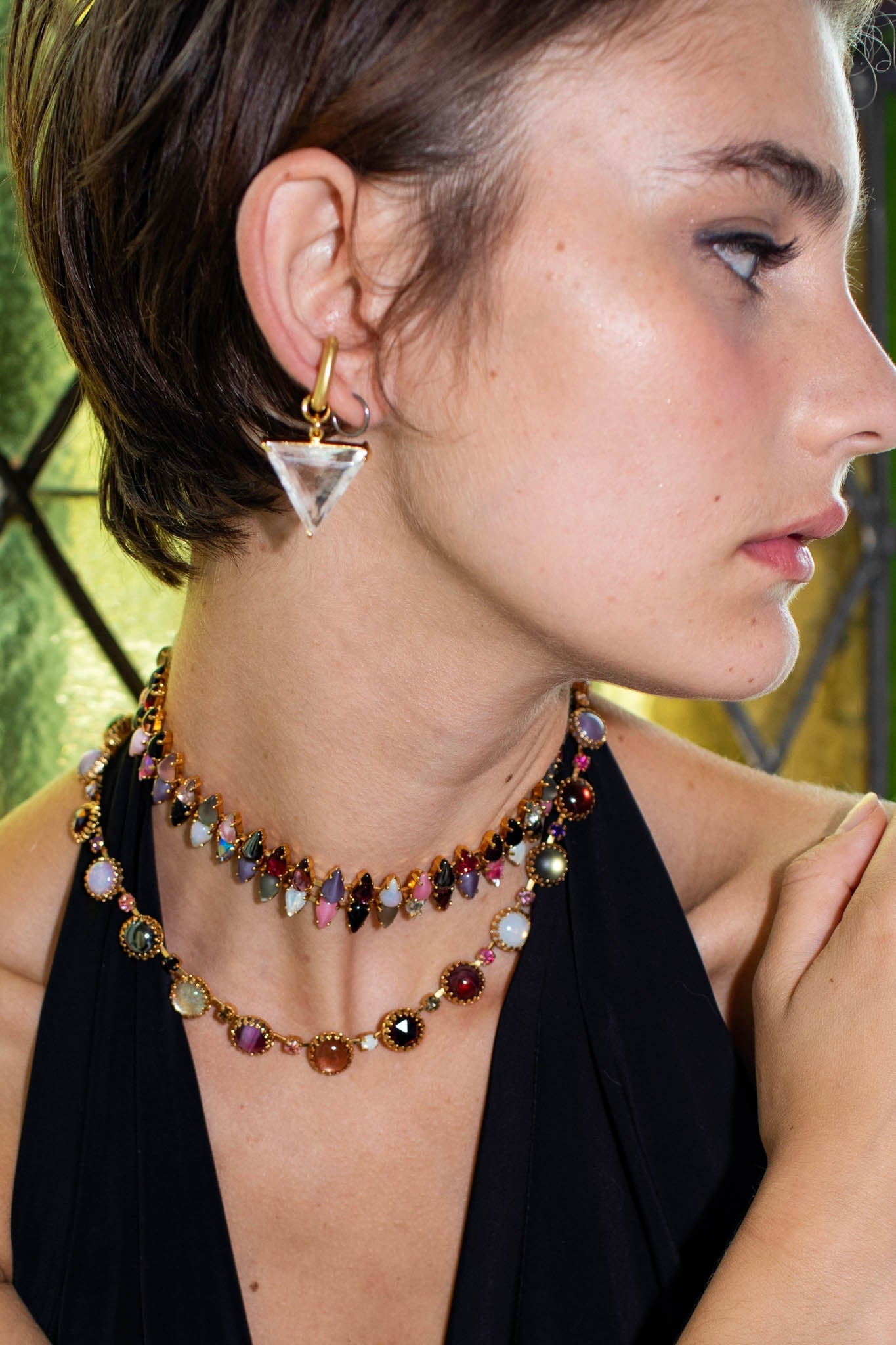 A gold-finish layering choker of multicolored vintage glass stones strung between clear crystals, shown from a different angle.