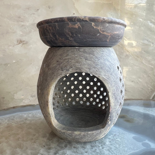 Hand-carved soapstone essential oil burner with pierced detailing, 3.5 inches tall, shown on a dark surface