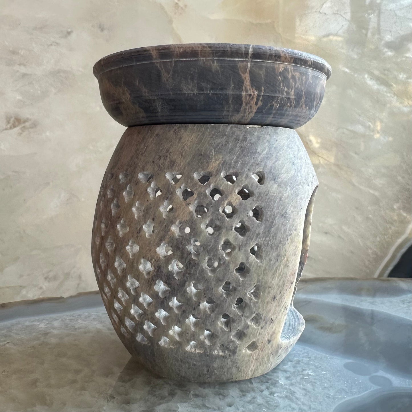 Hand-carved soapstone essential oil burner with pierced detailing, 3.5 inches tall, shown on a dark surface — view 2