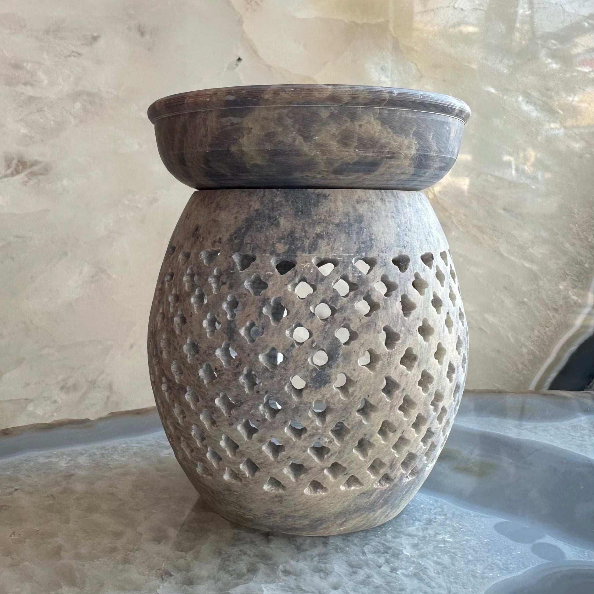 Hand-carved soapstone essential oil burner with pierced detailing, 3.5 inches tall, shown on a dark surface — view 3