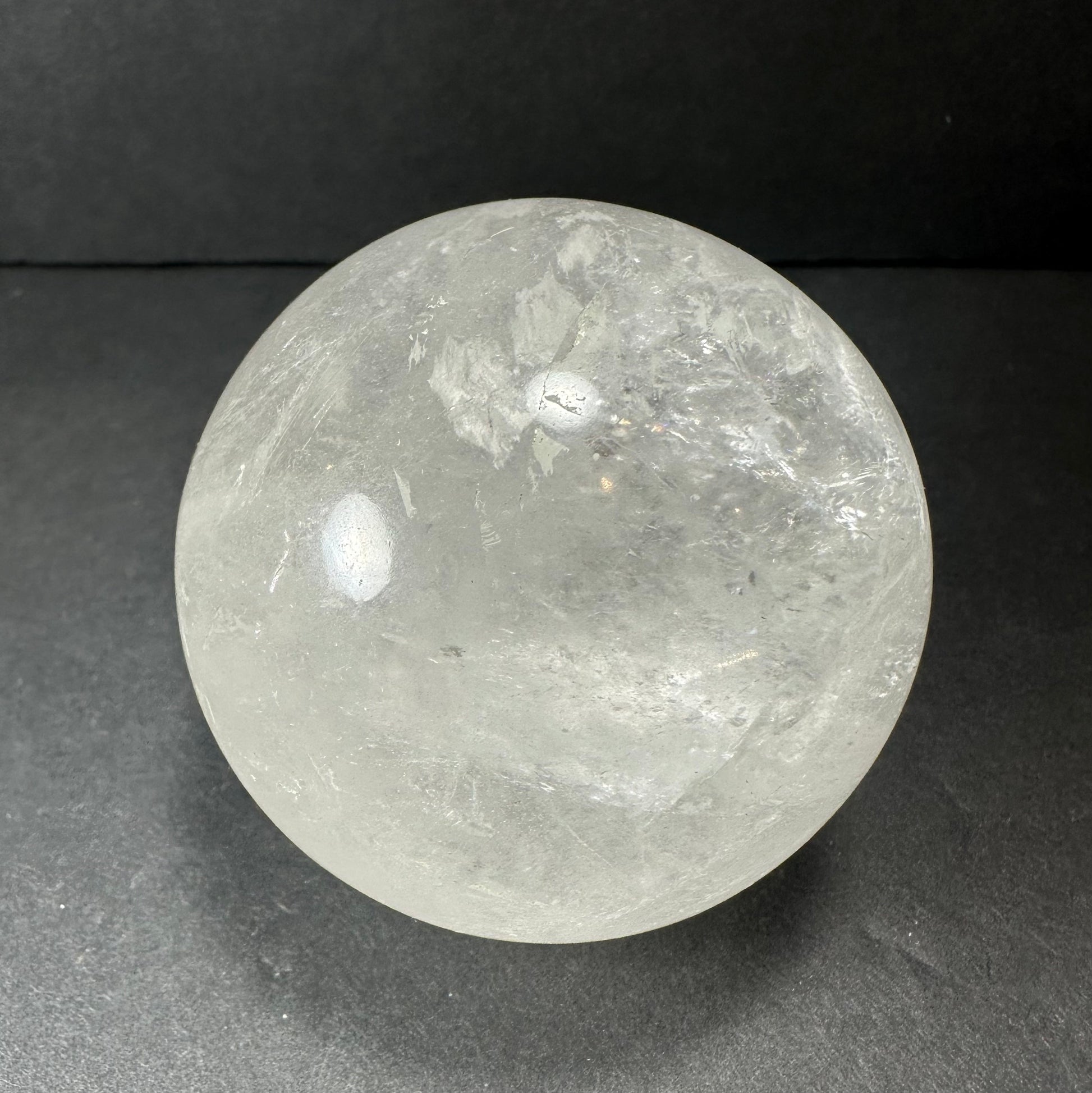 Clear quartz sphere showing internal veils and inclusions