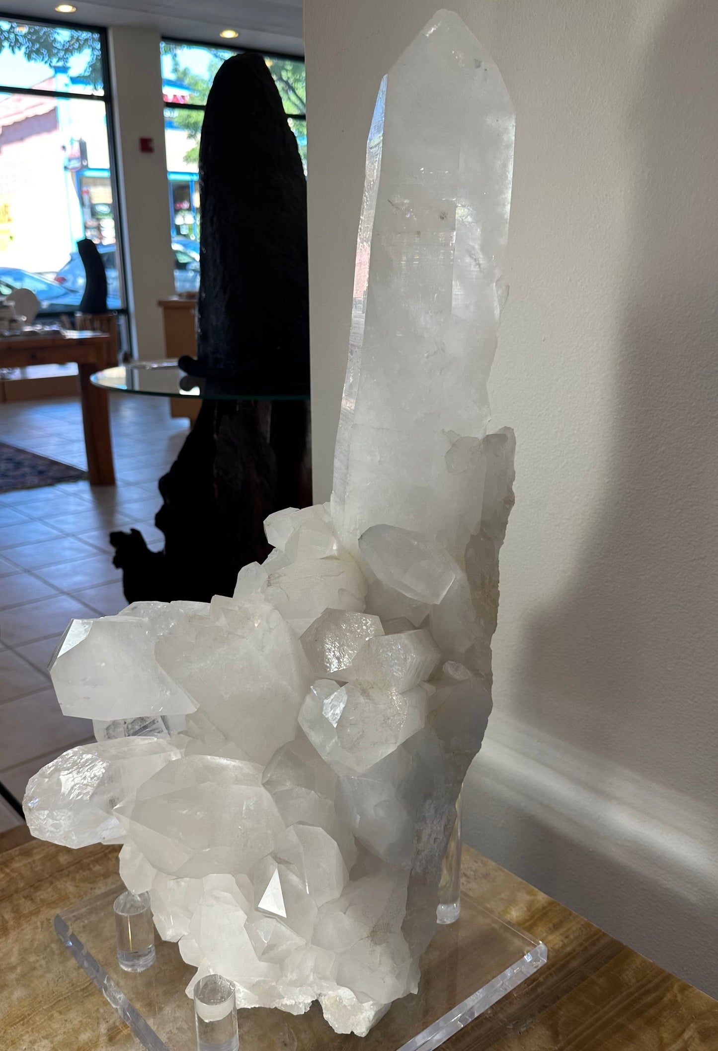 Large quartz crystal cluster with an extra-large central point on its acrylic stand