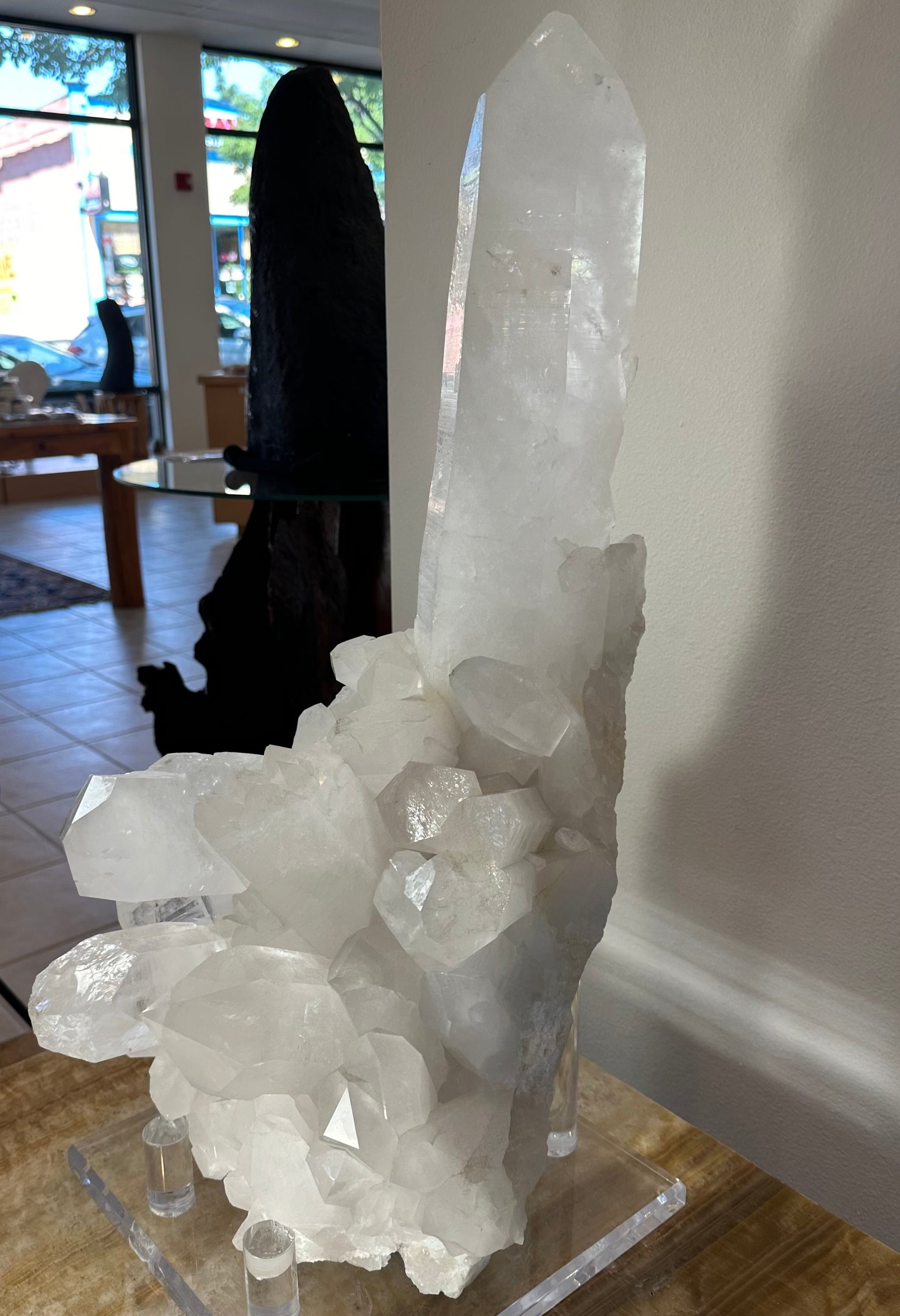 Large quartz crystal cluster with an extra-large central point on its acrylic stand