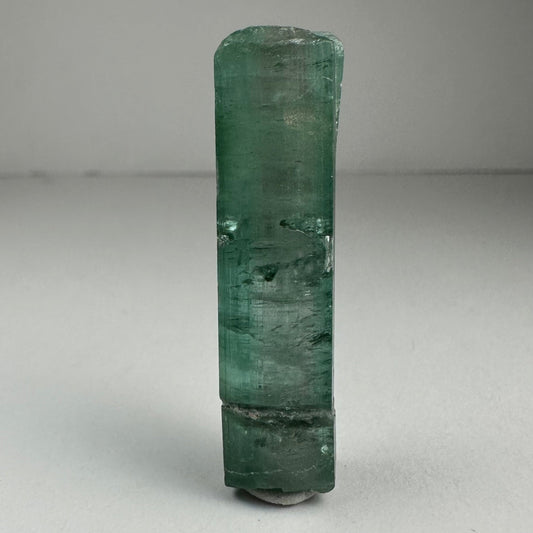 Blue indicolite tourmaline crystal specimen from Africa, 1.5 inches long, photographed against a dark background