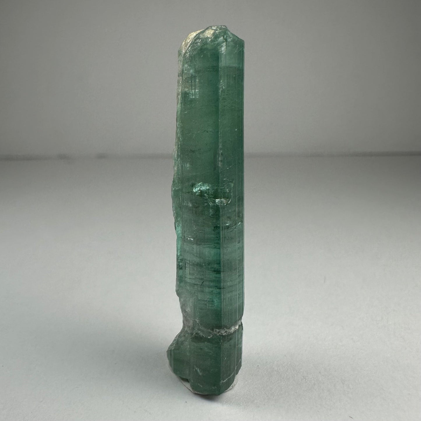Blue indicolite tourmaline crystal specimen from Africa, 1.5 inches long, photographed against a dark background — view 3