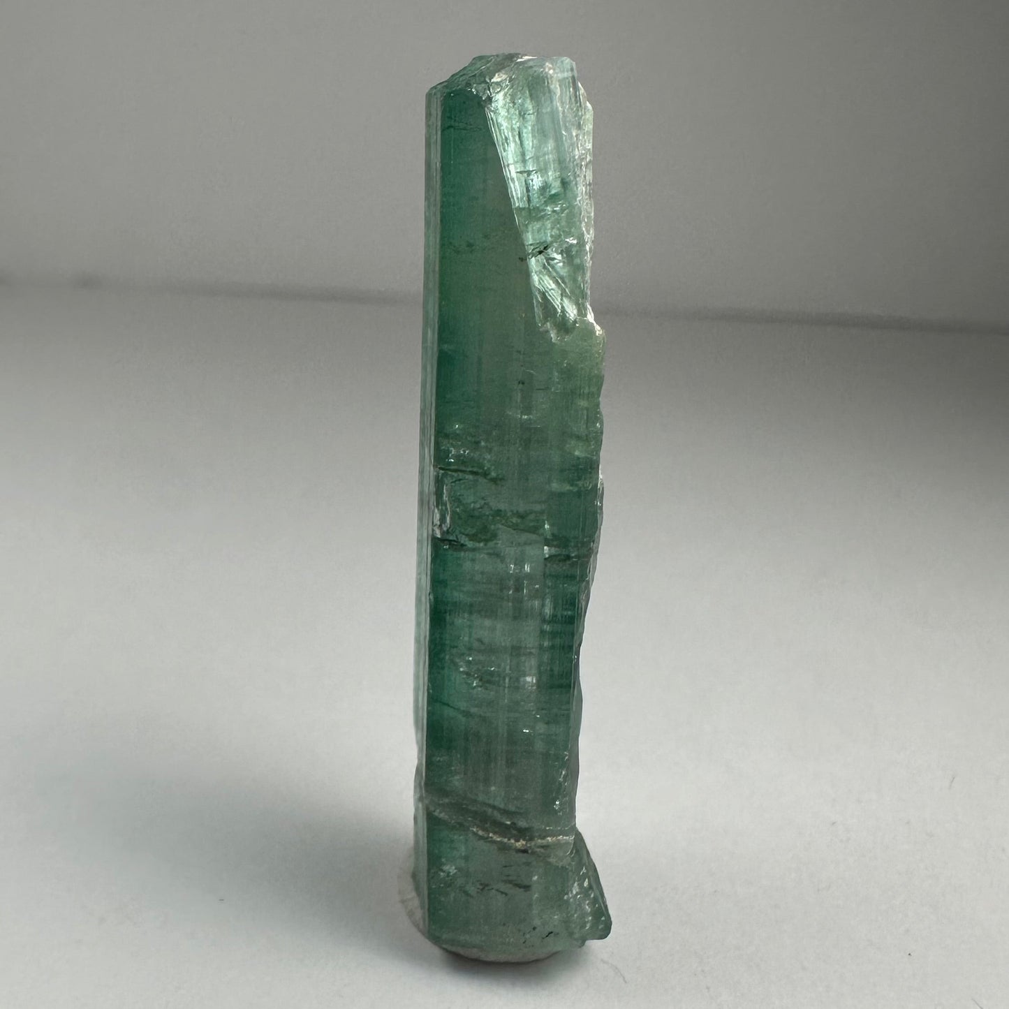 Blue indicolite tourmaline crystal specimen from Africa, 1.5 inches long, photographed against a dark background — view 4