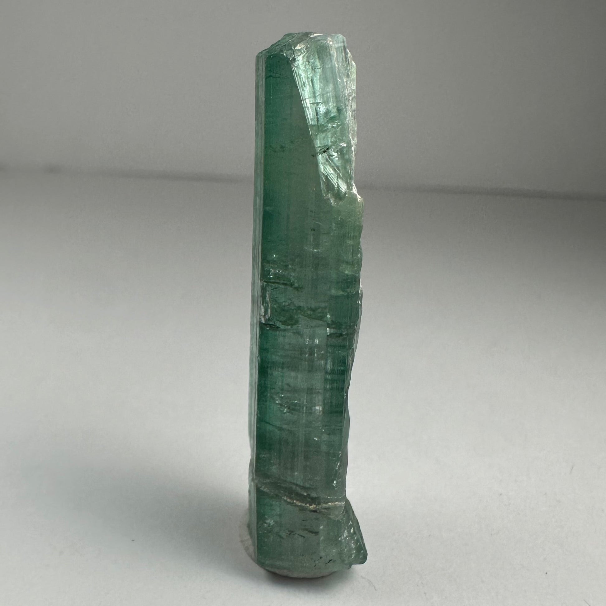 Blue indicolite tourmaline crystal specimen from Africa, 1.5 inches long, photographed against a dark background — view 4
