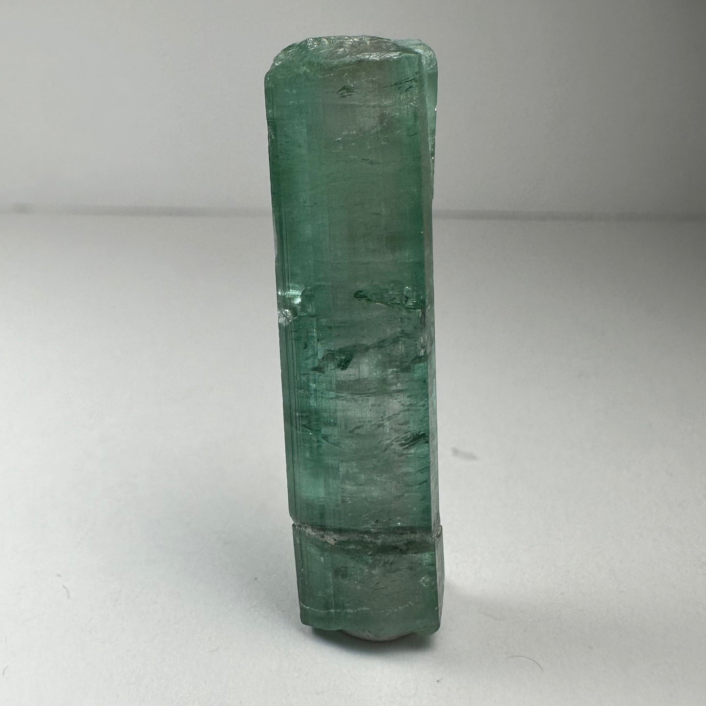 Blue indicolite tourmaline crystal specimen from Africa, 1.5 inches long, photographed against a dark background — view 5