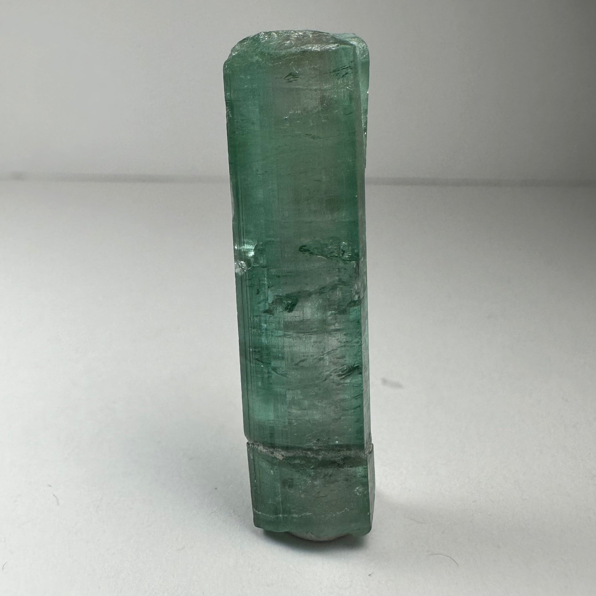 Blue indicolite tourmaline crystal specimen from Africa, 1.5 inches long, photographed against a dark background — view 5
