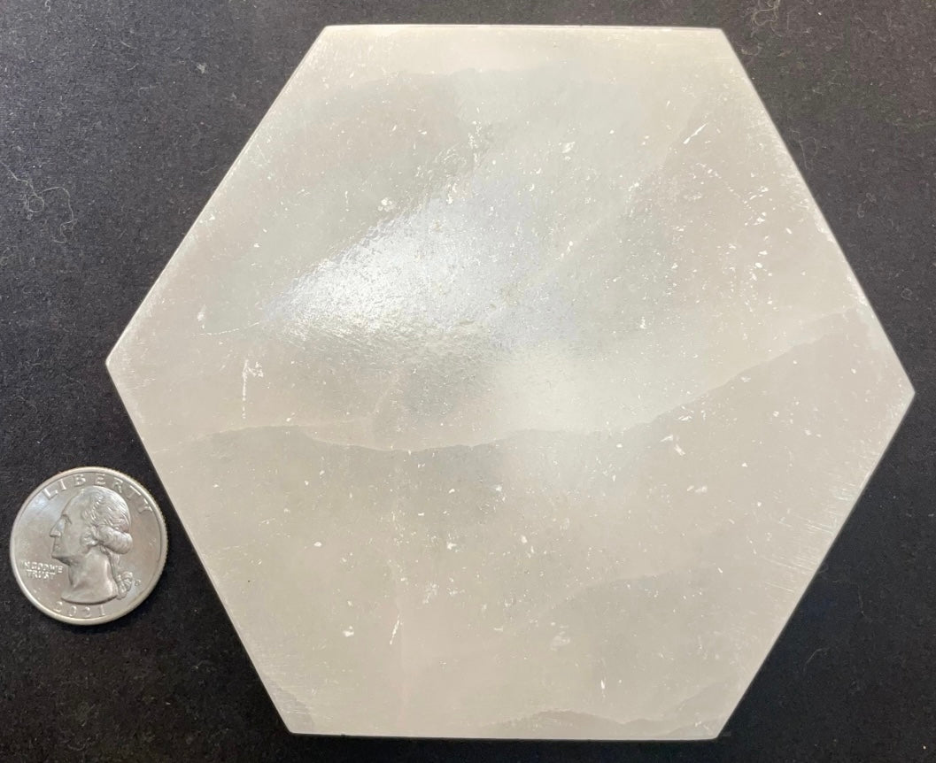 Round polished white selenite charging plate, 10cm across, translucent banded stone on a dark surface — view 4