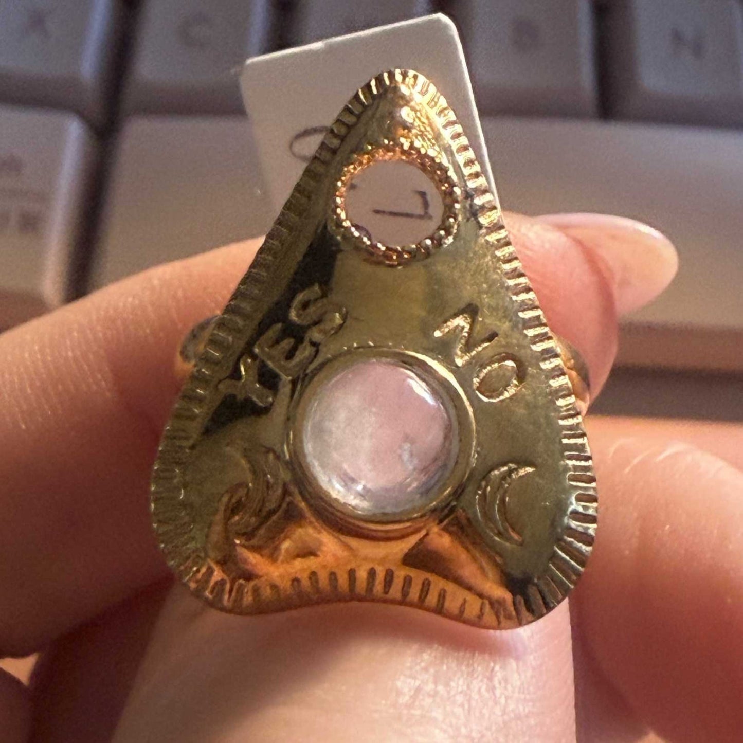 Planchette ring with a rainbow moonstone cabochon and moon phase detailing along the base
