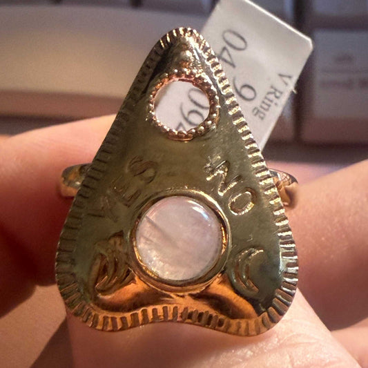 Gold vermeil planchette ring set with a rainbow moonstone cabochon, worn on a hand