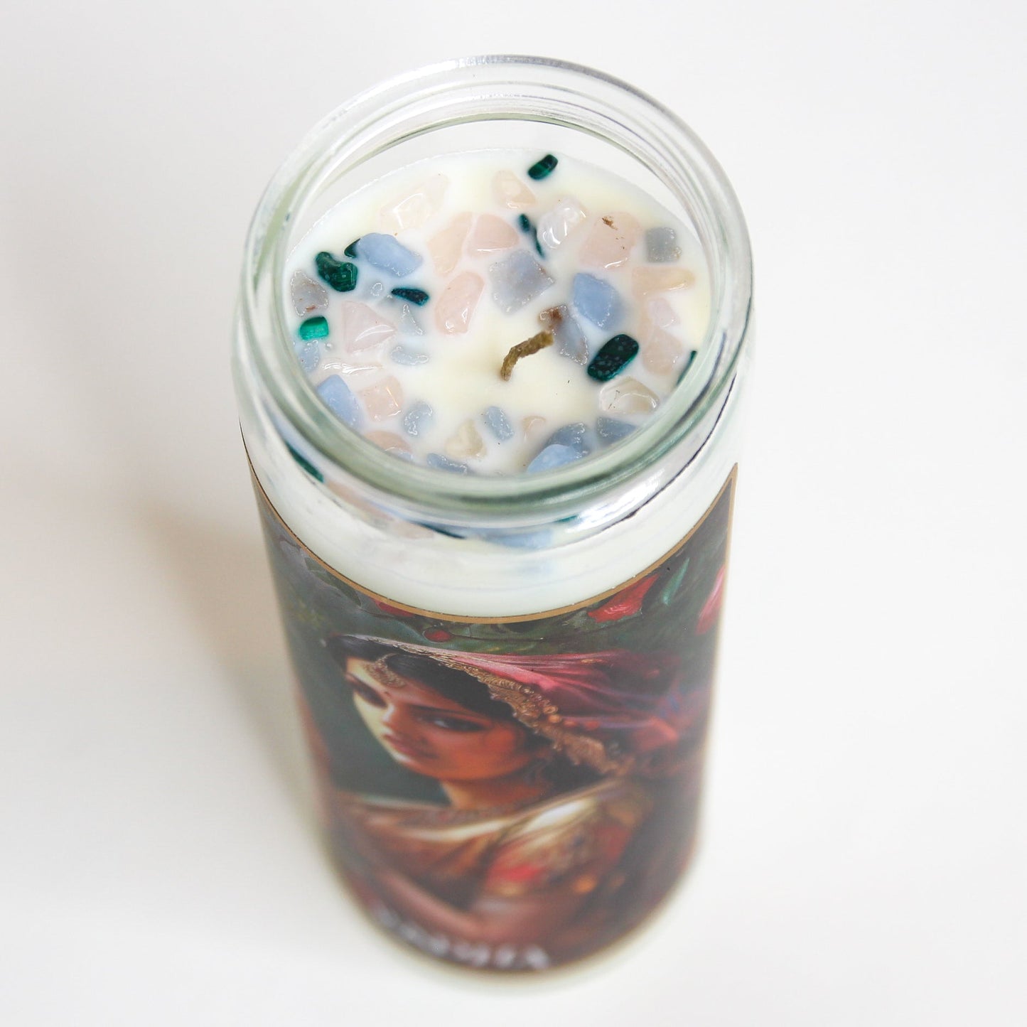 Radha Crystal Altar Candle in a 16 oz glass tumbler with an image of the goddess Radha on the label and rose quartz set into the wax — product photo 3