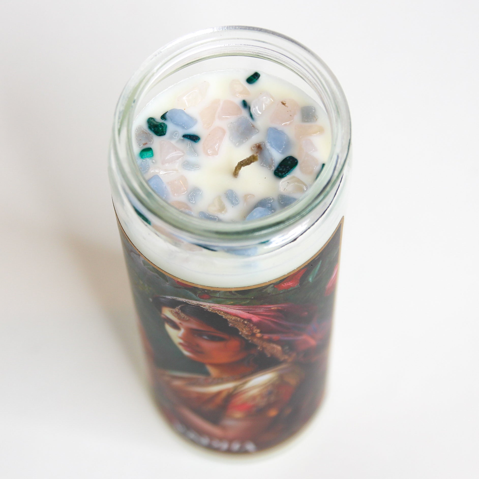 Radha Crystal Altar Candle in a 16 oz glass tumbler with an image of the goddess Radha on the label and rose quartz set into the wax — product photo 3