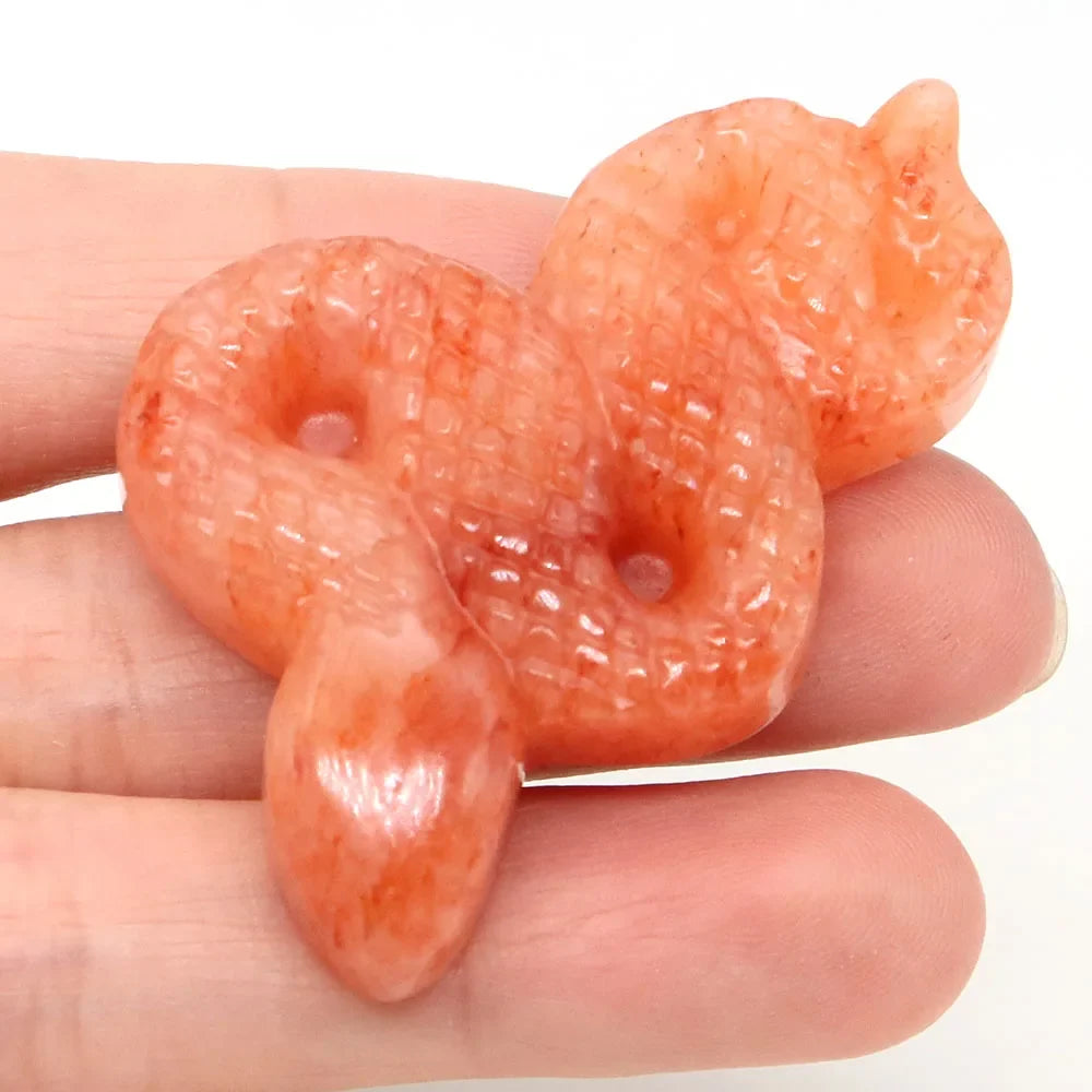 Carved gemstone snake figurine coiled on a dark surface — view 7 of 12