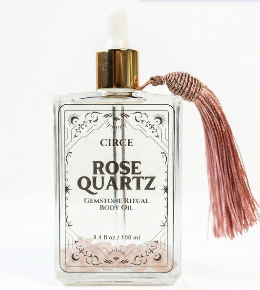 Rose quartz gemstone shimmer body oil in an apothecary glass bottle with rose quartz crystals