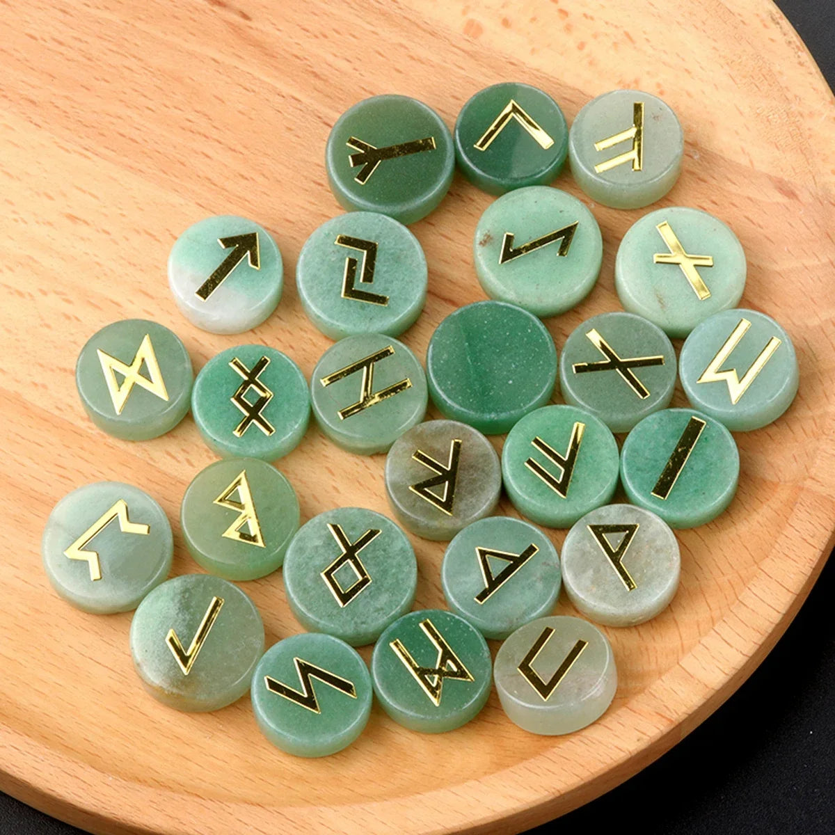 Set of round polished crystal runes engraved with runic symbols, scattered on a dark surface — view 6 of 12