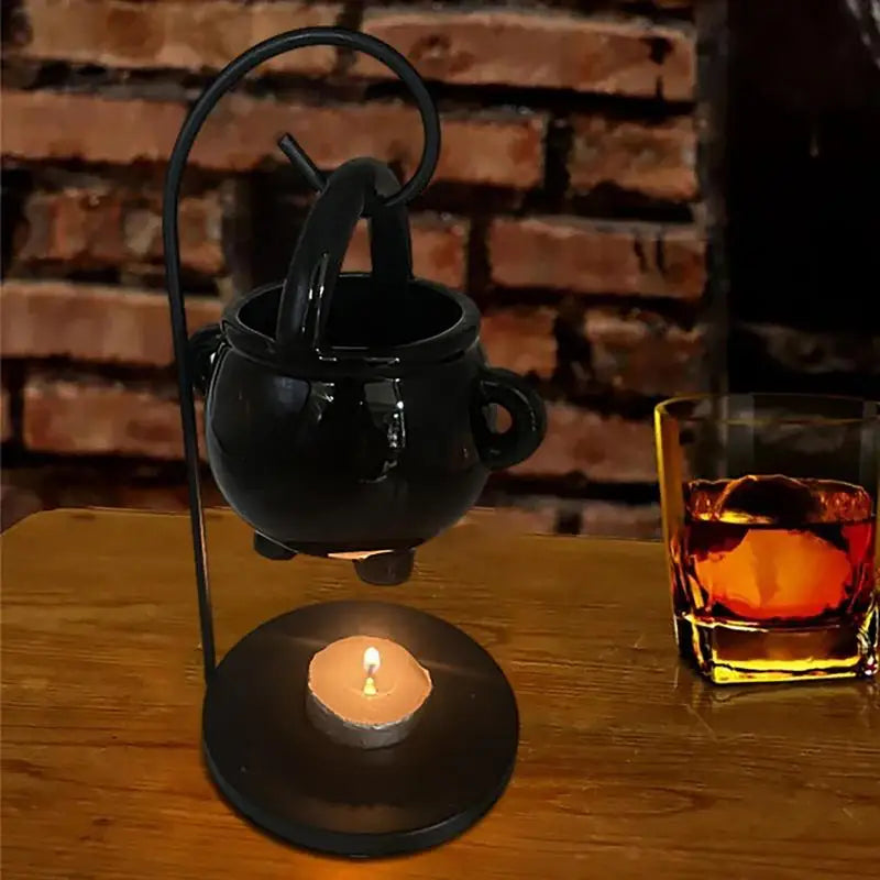 Hanging ceramic cauldron wax burner suspended from a black metal stand — view 5 of 5