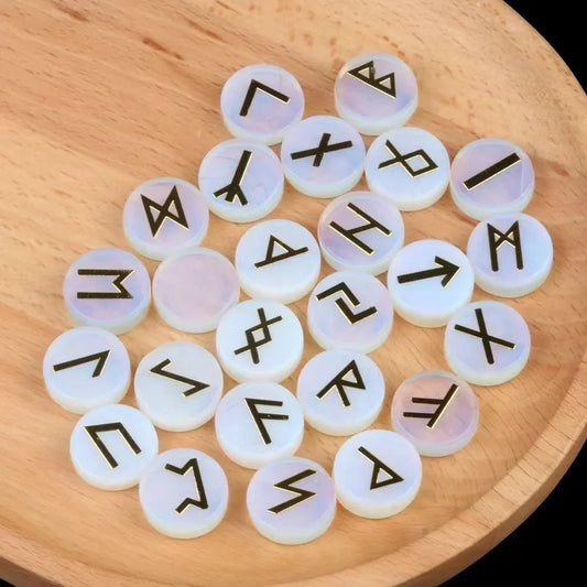 Set of round polished crystal runes engraved with runic symbols, scattered on a dark surface — view 1 of 12